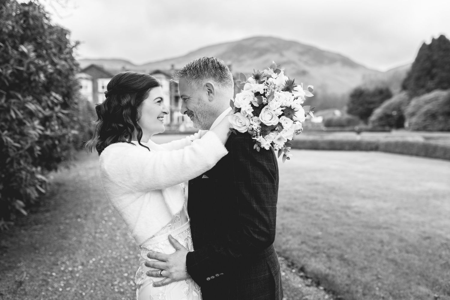 Romantic black and white wedding photos showing intimate moments between couples in scenic outdoor settings.