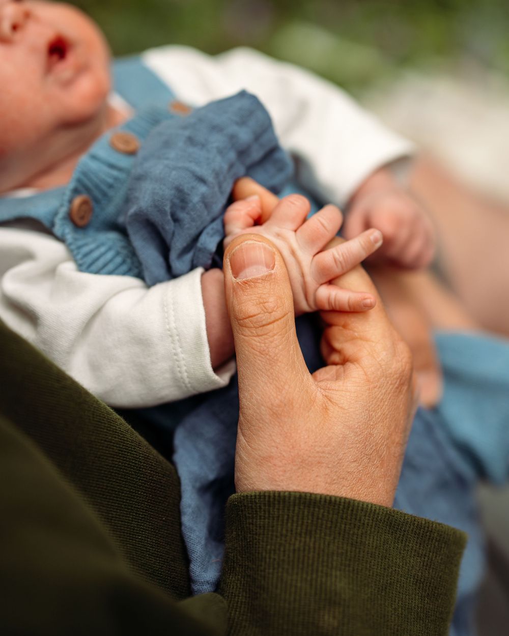 A close-up of hands holding together in a tender moment.