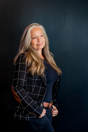 Professional portrait series showing a realtor in a black and white checkered blazer against a dark background.