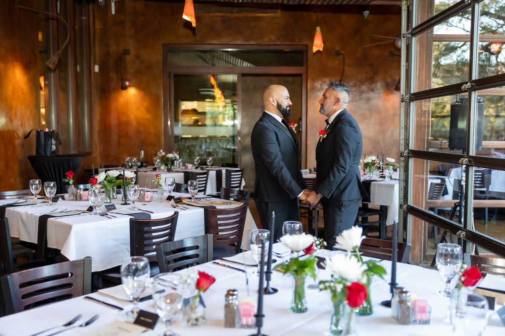 Elegant restaurant interior with exposed wood beams, white tablecloths, and soft lighting creating a rustic ambiance.