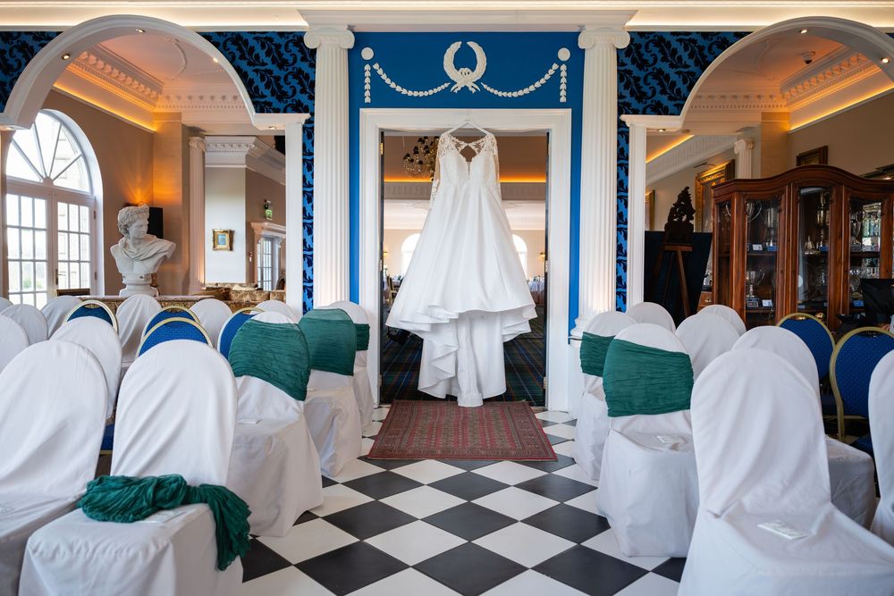 Elegant restaurant interior with checkered floor, white tablecloths, and teal accents features ornate decor and chandeliers.