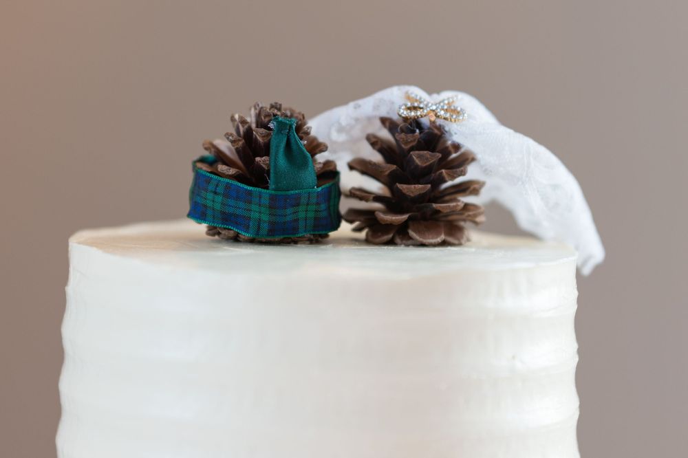 White ceramic ornaments and pinecones arranged on a neutral surface create a minimalist winter display.