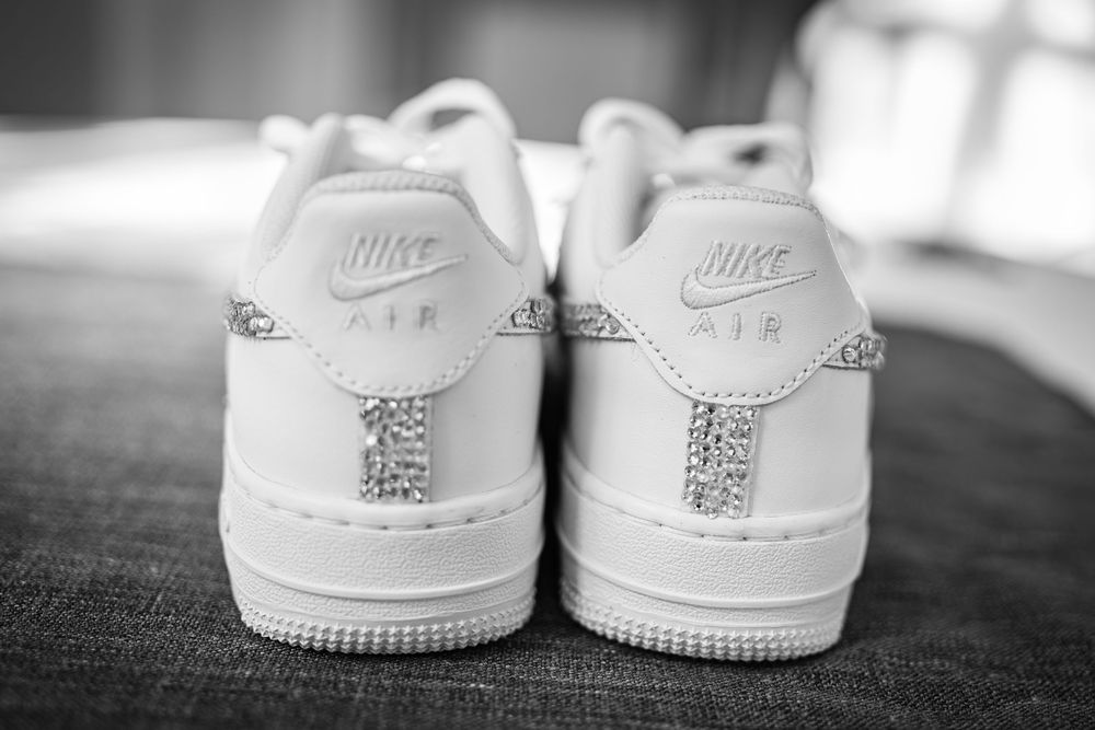 Close-up details of white Nike Air Force 1 sneakers shown from different angles in black and white photography.