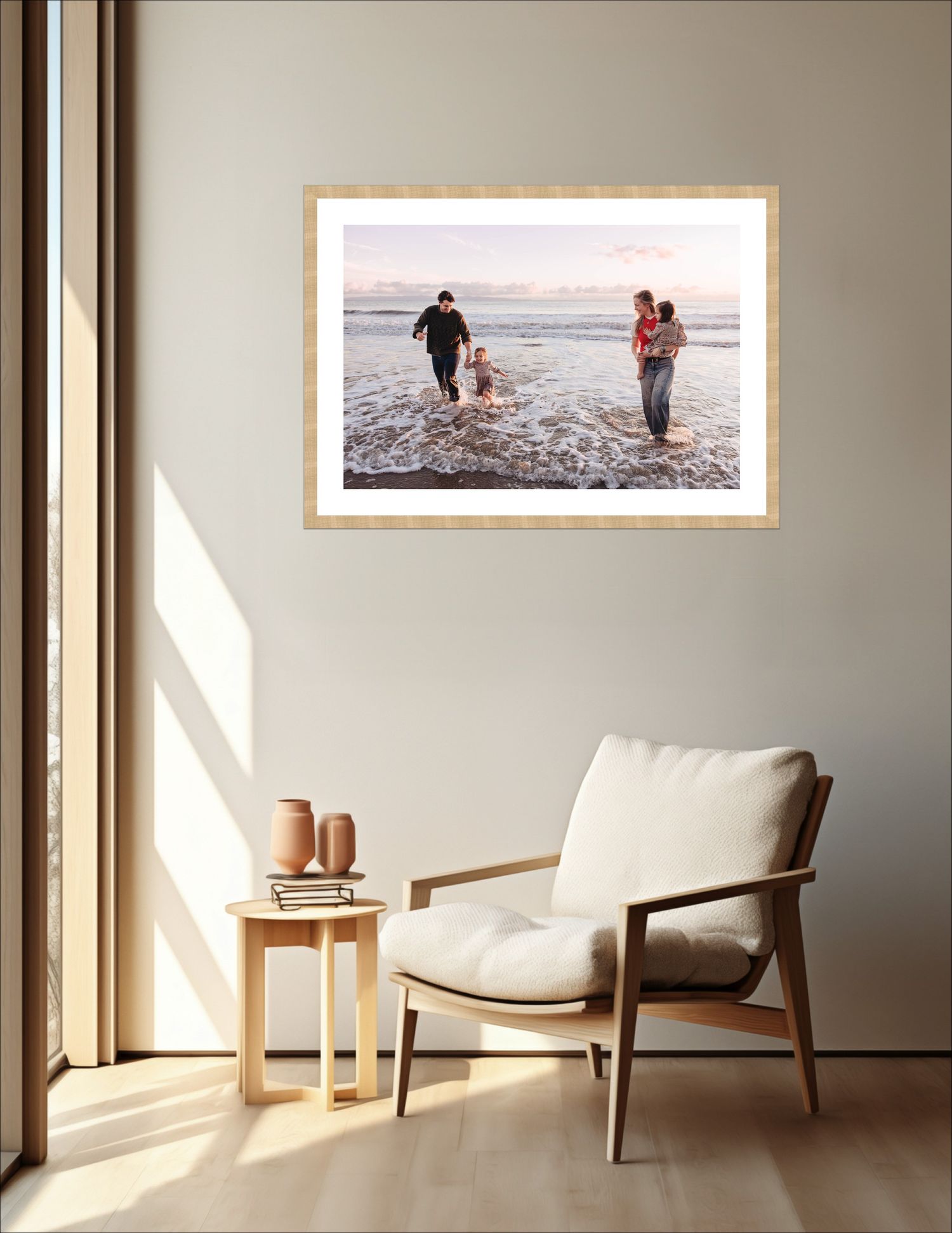 Minimalist interior design featuring a cream-colored armchair and framed artwork in a sunlit room.