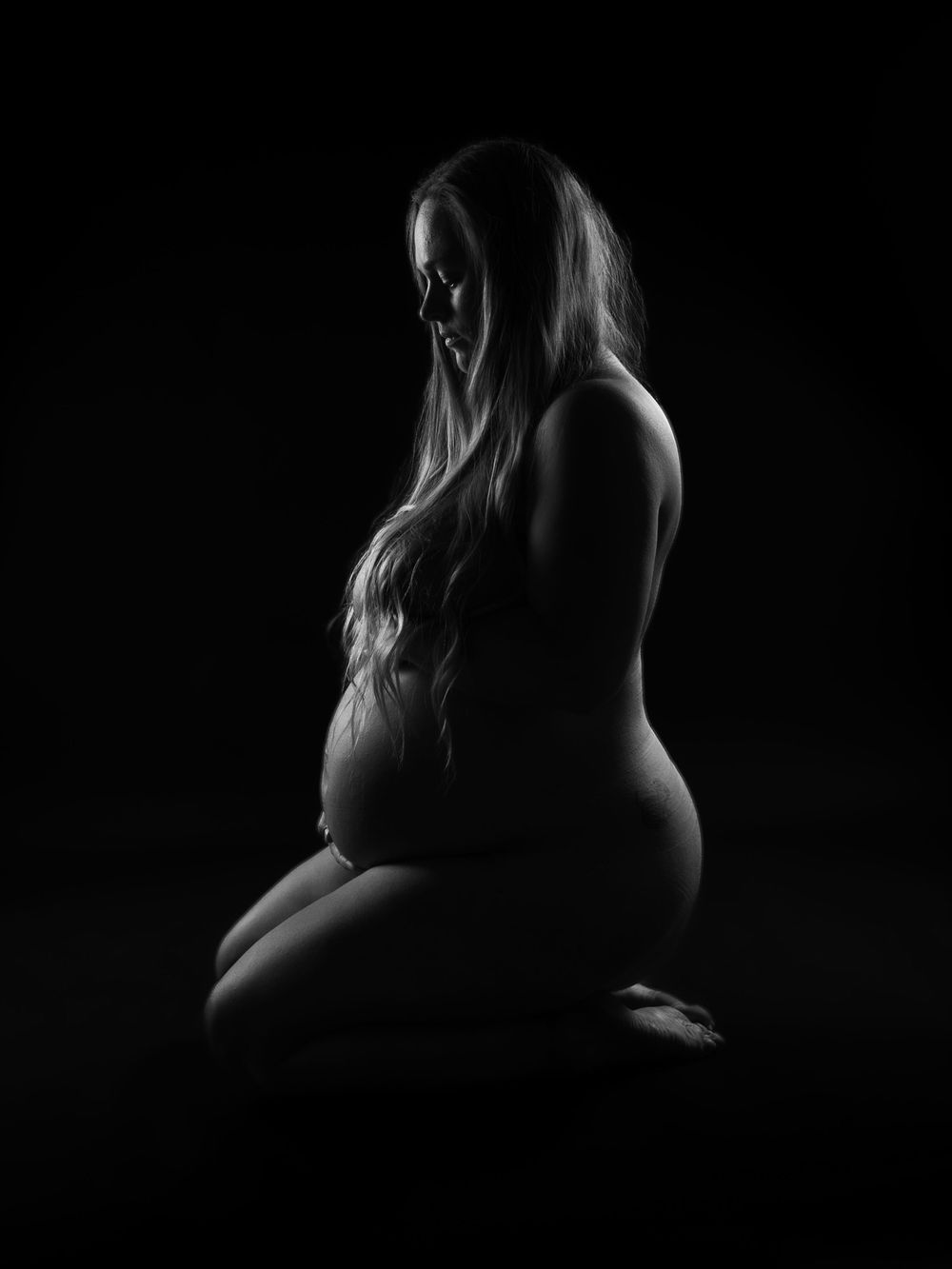 Artistic black and white silhouette of a pregnant woman's body showing the progression of pregnancy in multiple frames.