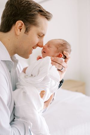 Three tender moments between a parent and baby in white clothing against a light background.