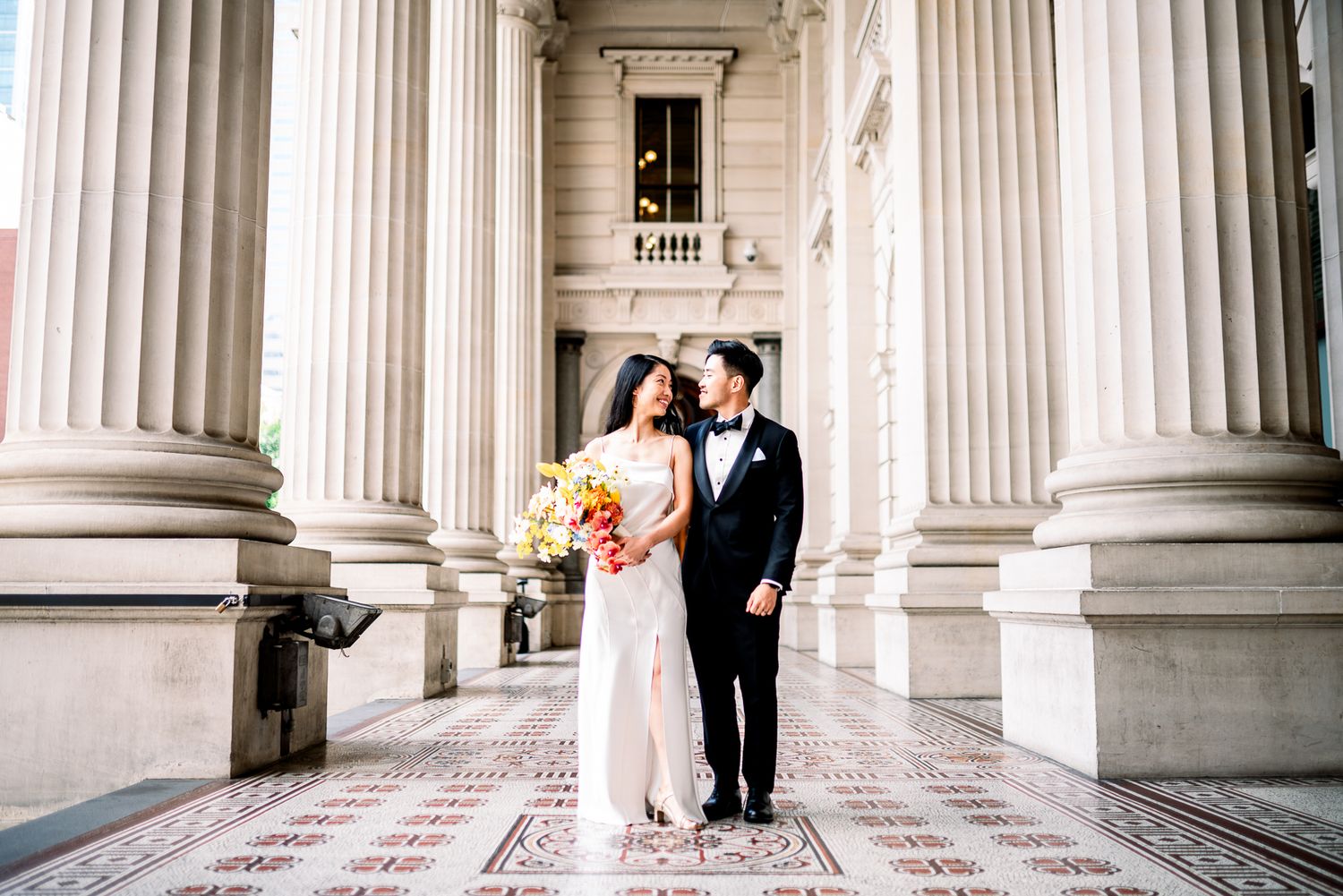 Elegant wedding couple poses at the Parliament building in Melbourne taken by a Melbourne couples, engagement and pre-wedding photographer.
