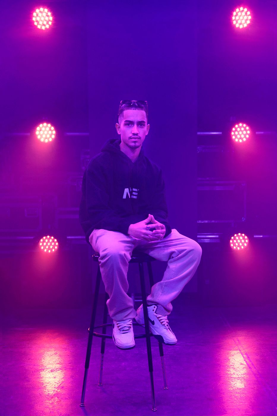Portrait photography featuring a male model seated on a chair with lights in the background, created by commercial photographer Chris Z of Z