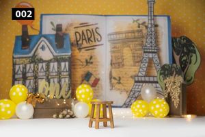 Paris themed party backdrop with yellow polka dot balloons and small wooden stool against vintage Eiffel Tower background.