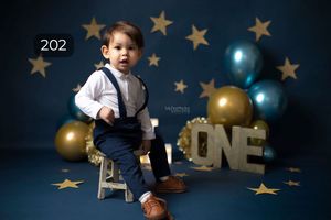 Birthday setup with gold stars, balloons and ONE letters on dark blue background.