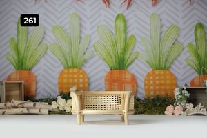 Tropical themed backdrop with pineapple designs and wooden bench for photo sessions.