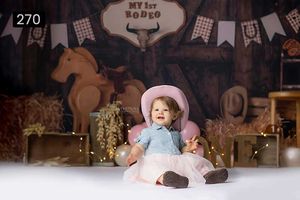 Western rodeo themed photography backdrop with rustic decorations and bunting.