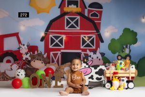 Baby's first birthday cake smash photo with farm theme backdrop, colorful toys, and cow print decorations.