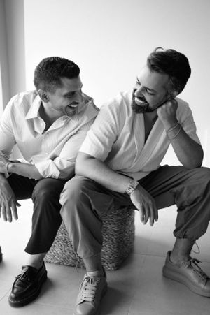 Candid black and white photo of two people sharing a genuine laugh while sitting together.