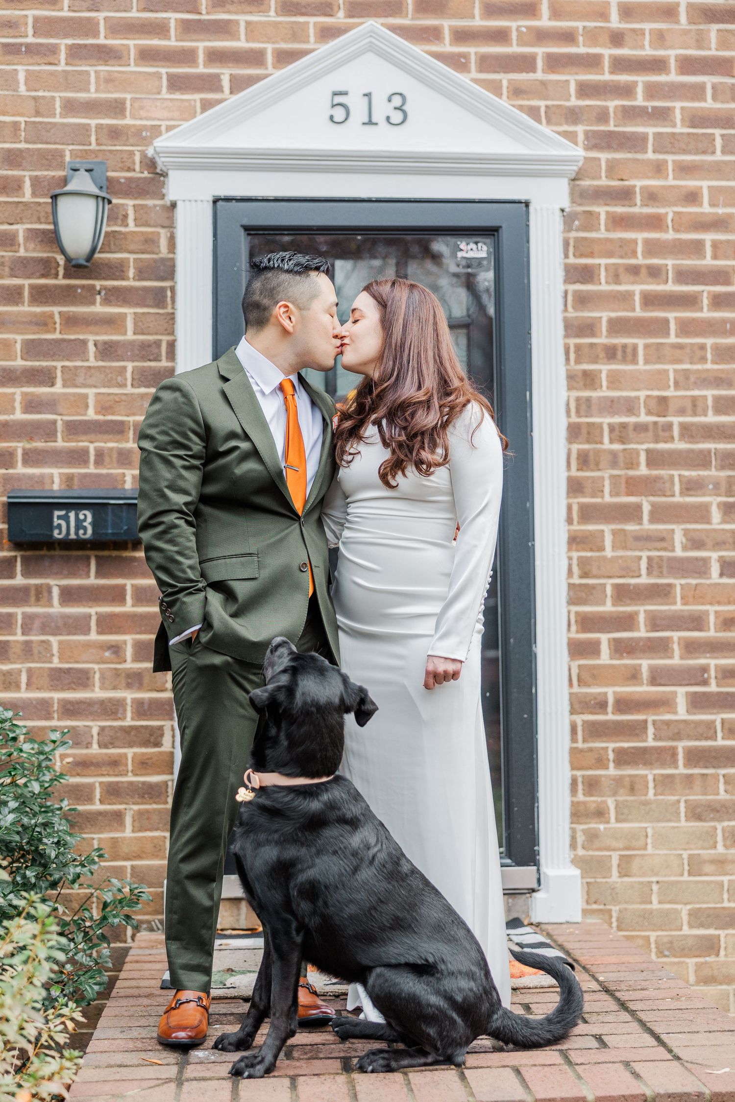 A couple shares a romantic moment on their porch with their black dog at address 513.