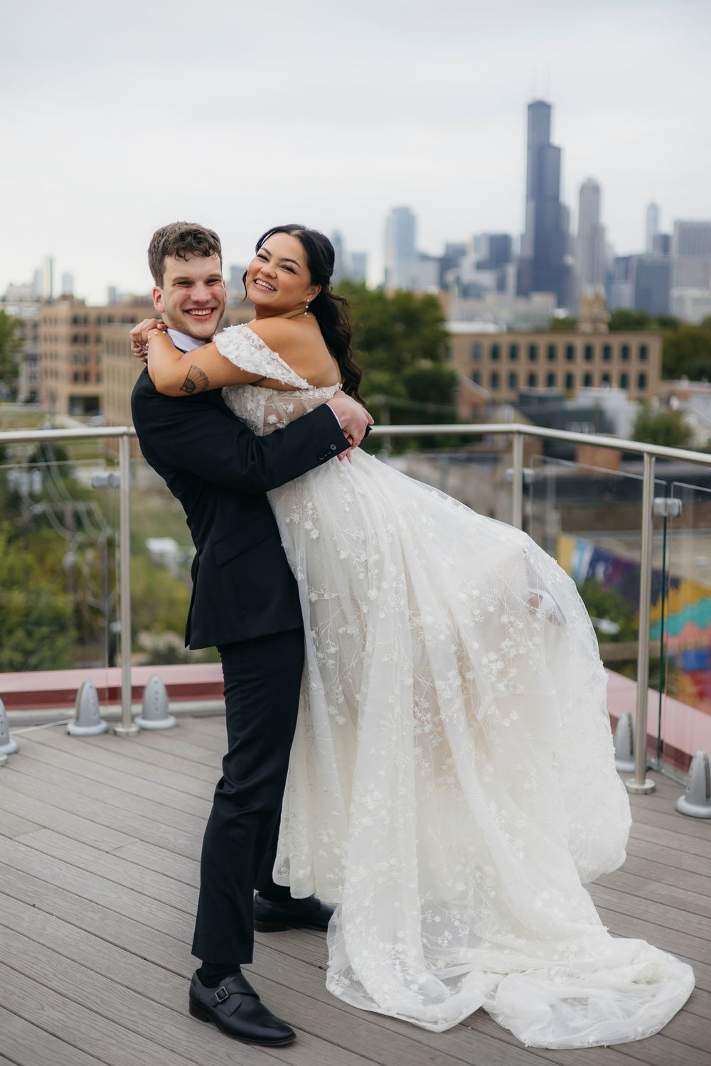 Newlyweds share romantic dance moves on a rooftop deck with the Chicago skyline visible in the background.
