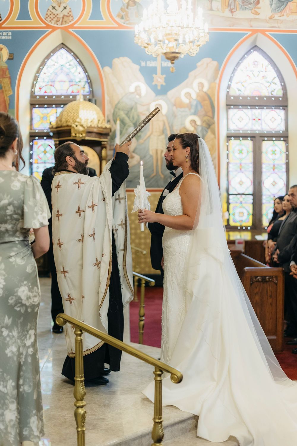 Traditional Orthodox Christian wedding ceremony taking place inside an ornate Chicago church with gold details and stained glass windows.