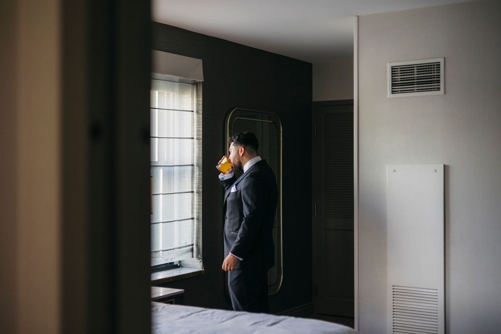 A Groom is having a drink in the Chicago suite while calming down his nerves before wedding