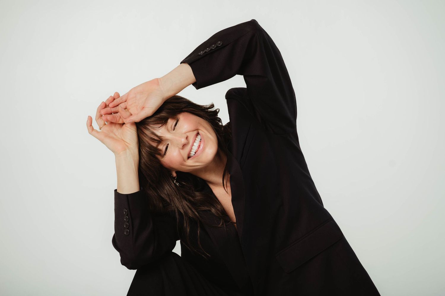 Person in black hoodie posing playfully against white background in series of expressive movements.