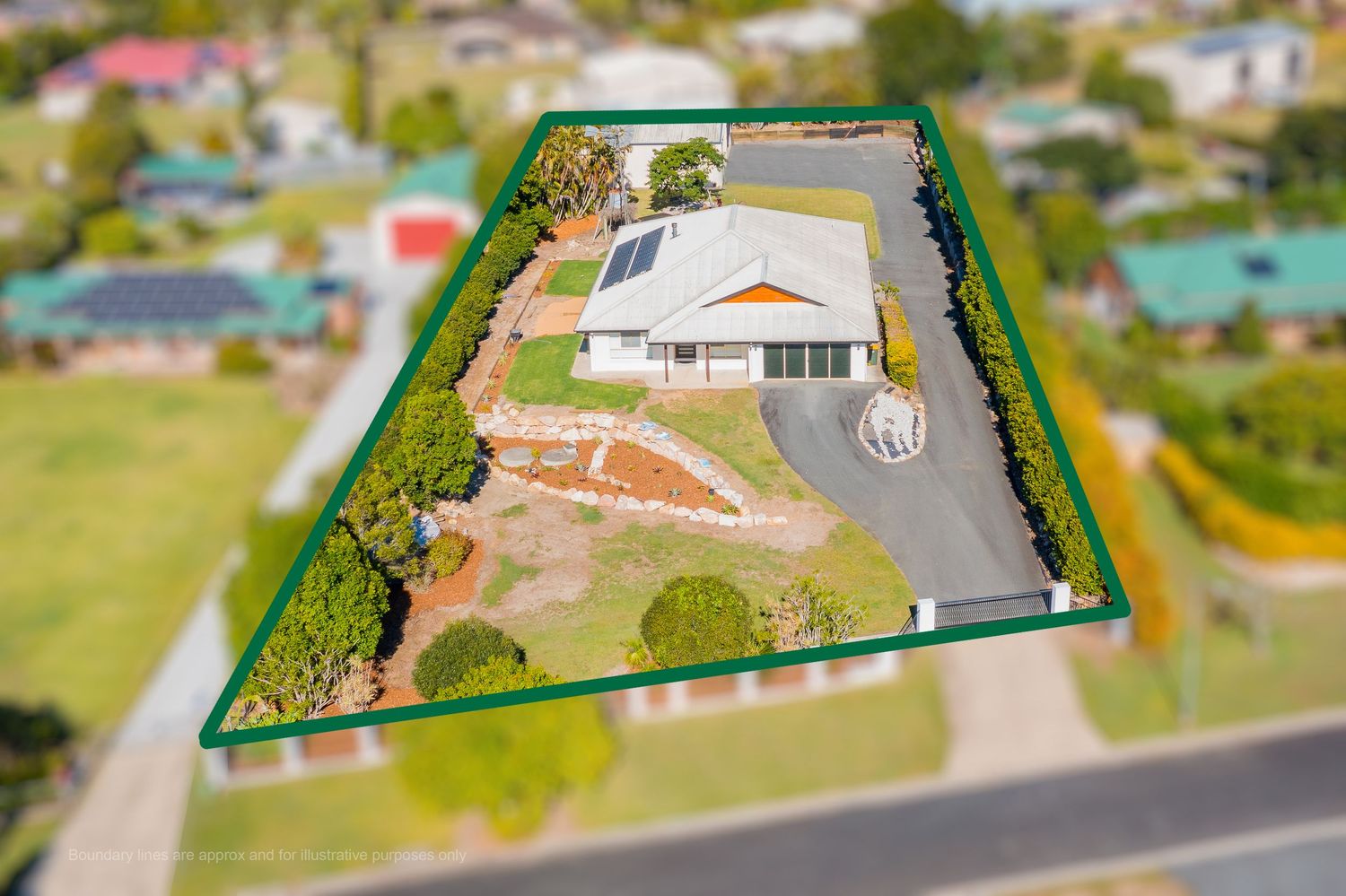 Aerial tilt-shift view of a single-story home on a large corner block with circular driveway and solar panels.