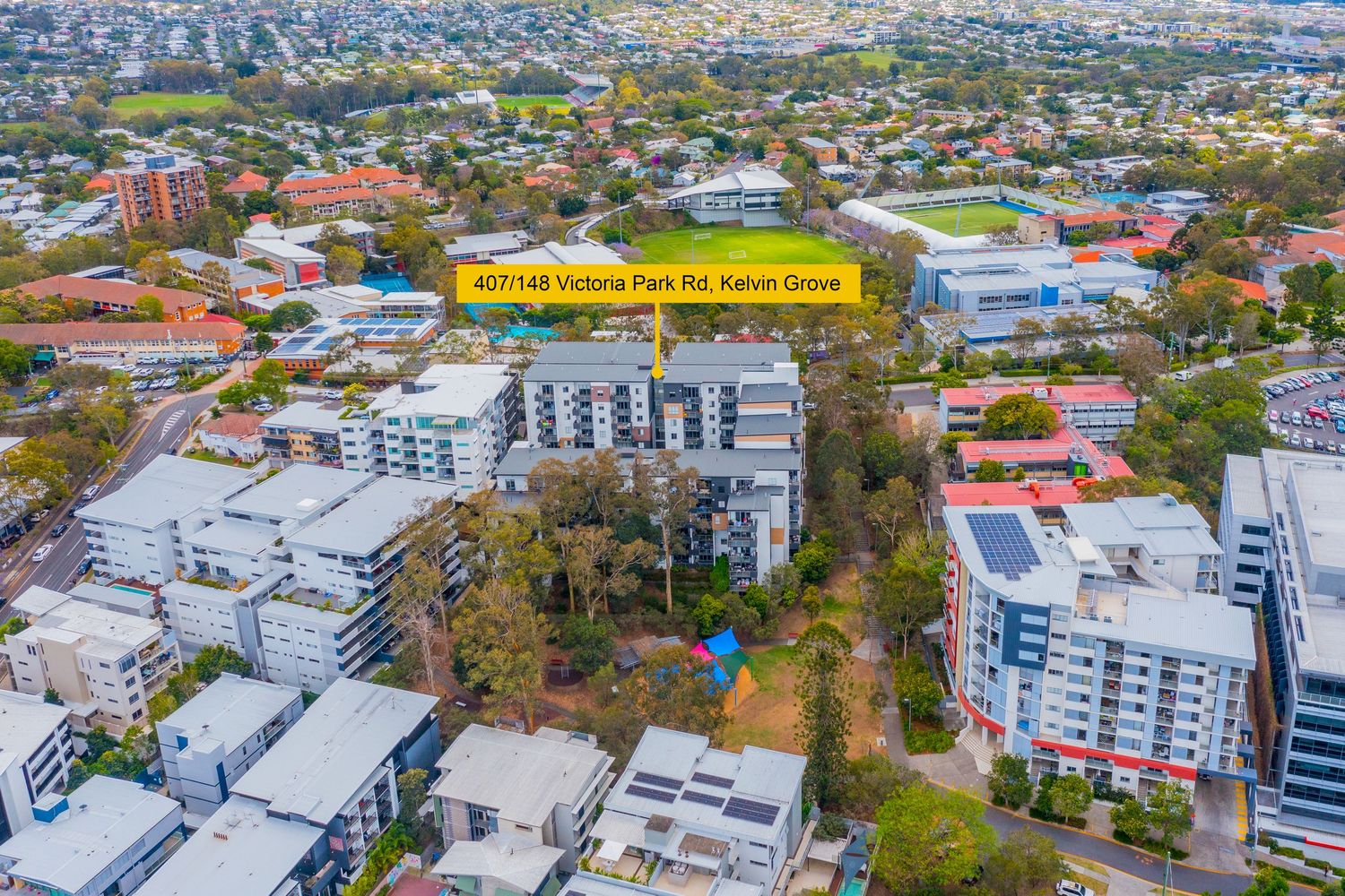 Aerial view of Victoria Park Rd Kelvin Grove surrounded by modern apartment complexes near Brisbane CBD.