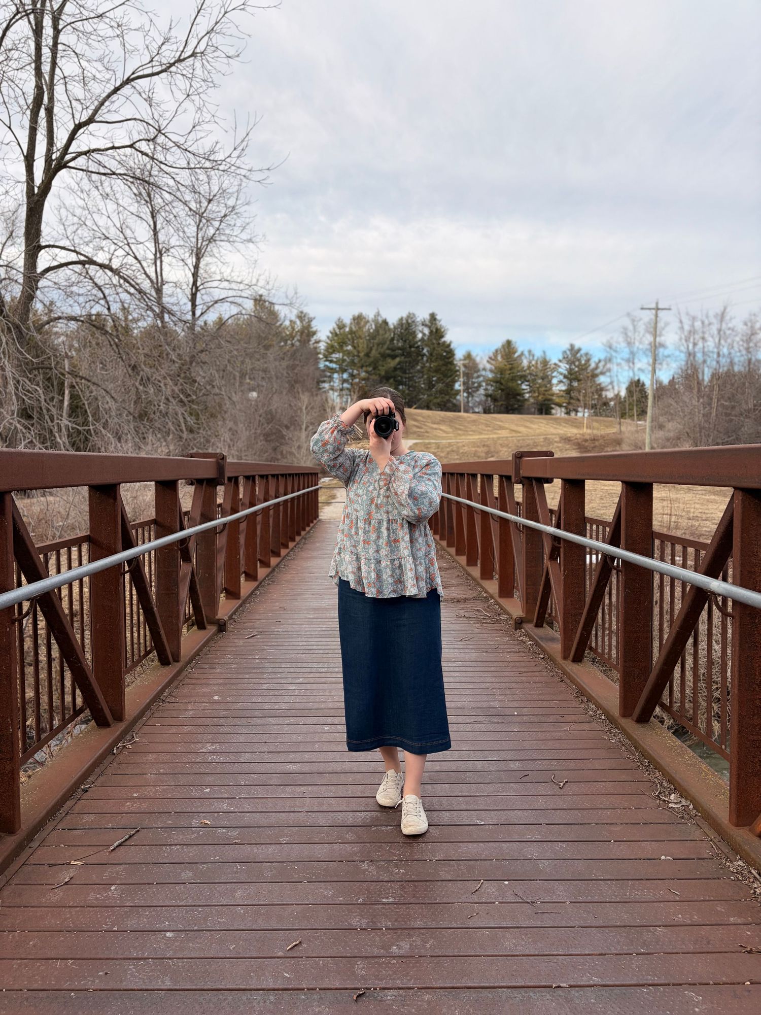 A sequence of photos showing a wooden boardwalk bridge extending over a natural area on a cloudy winter day.