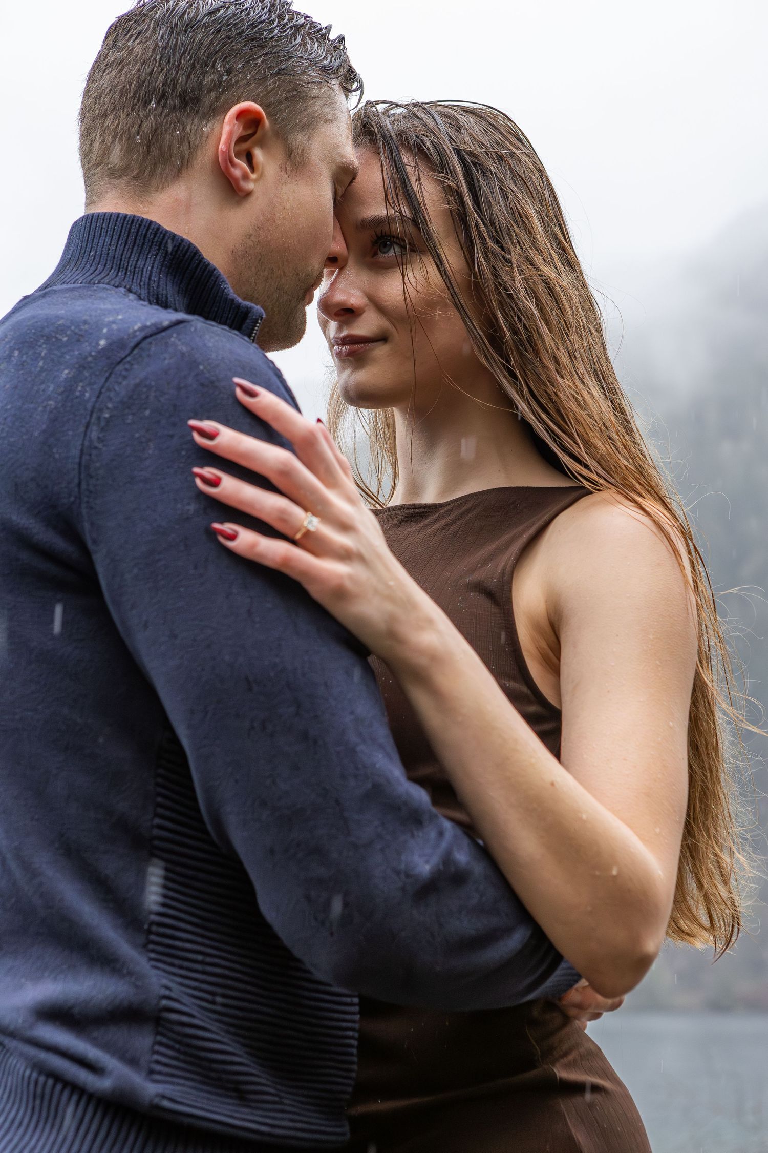 Close-up of intimate embrace between couple wearing navy and neutral colors.