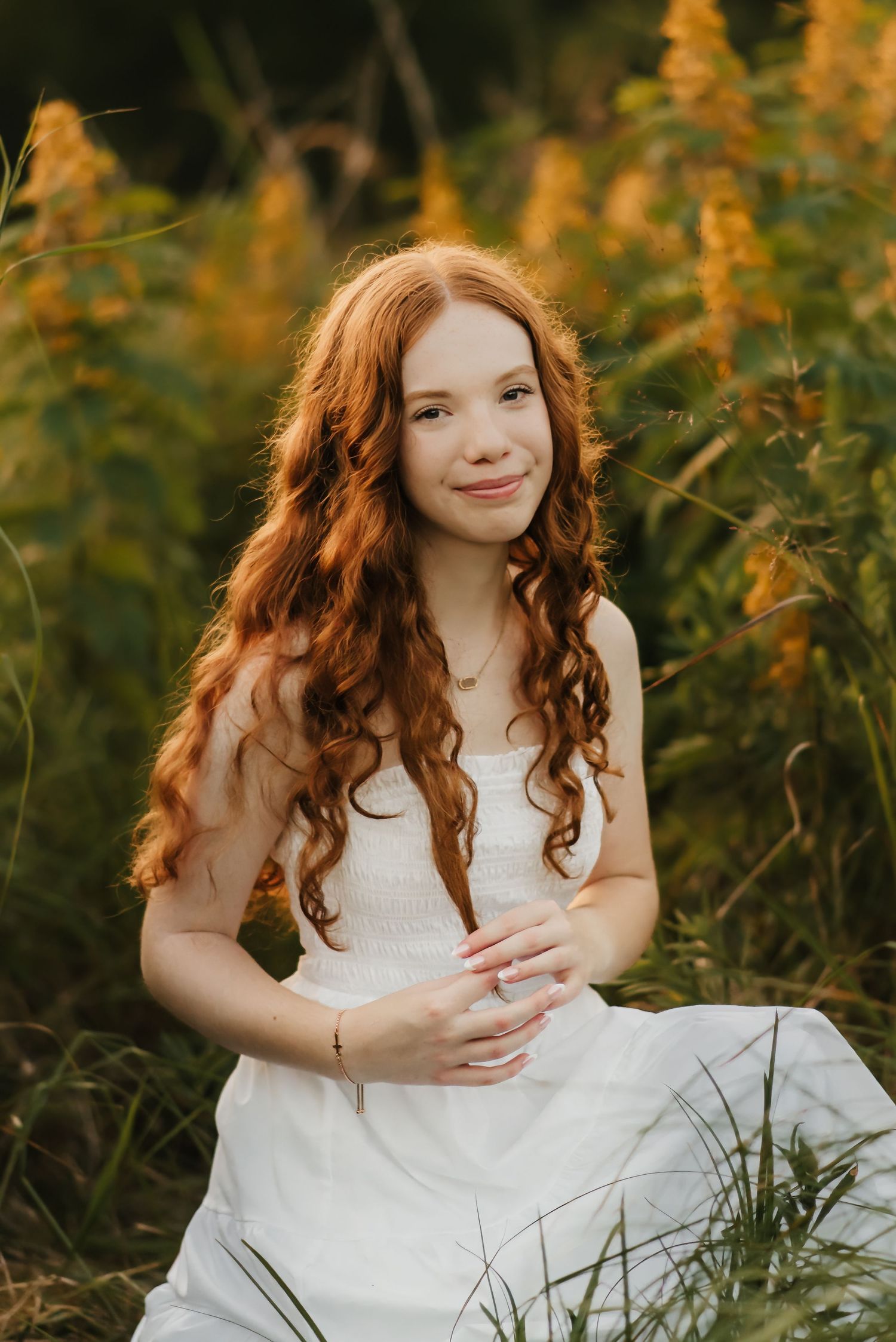 Senior girl laughs in field during senior photo session