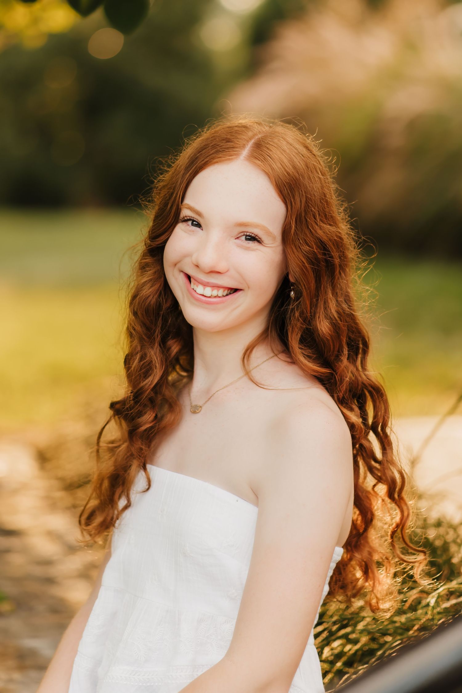 Senior girl laughs in field during senior photo session