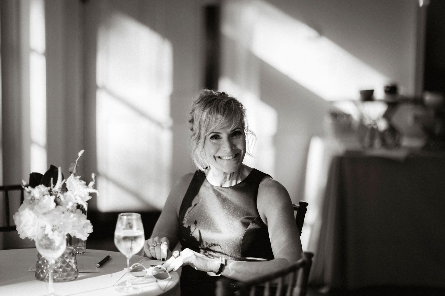 Black and white wedding reception photos showing guests dining and dancing in an elegant venue with dramatic lighting.