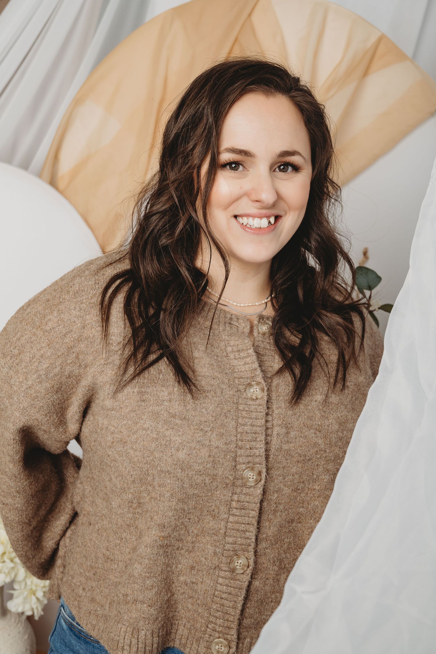 Portrait of person wearing brown sweater against light background.