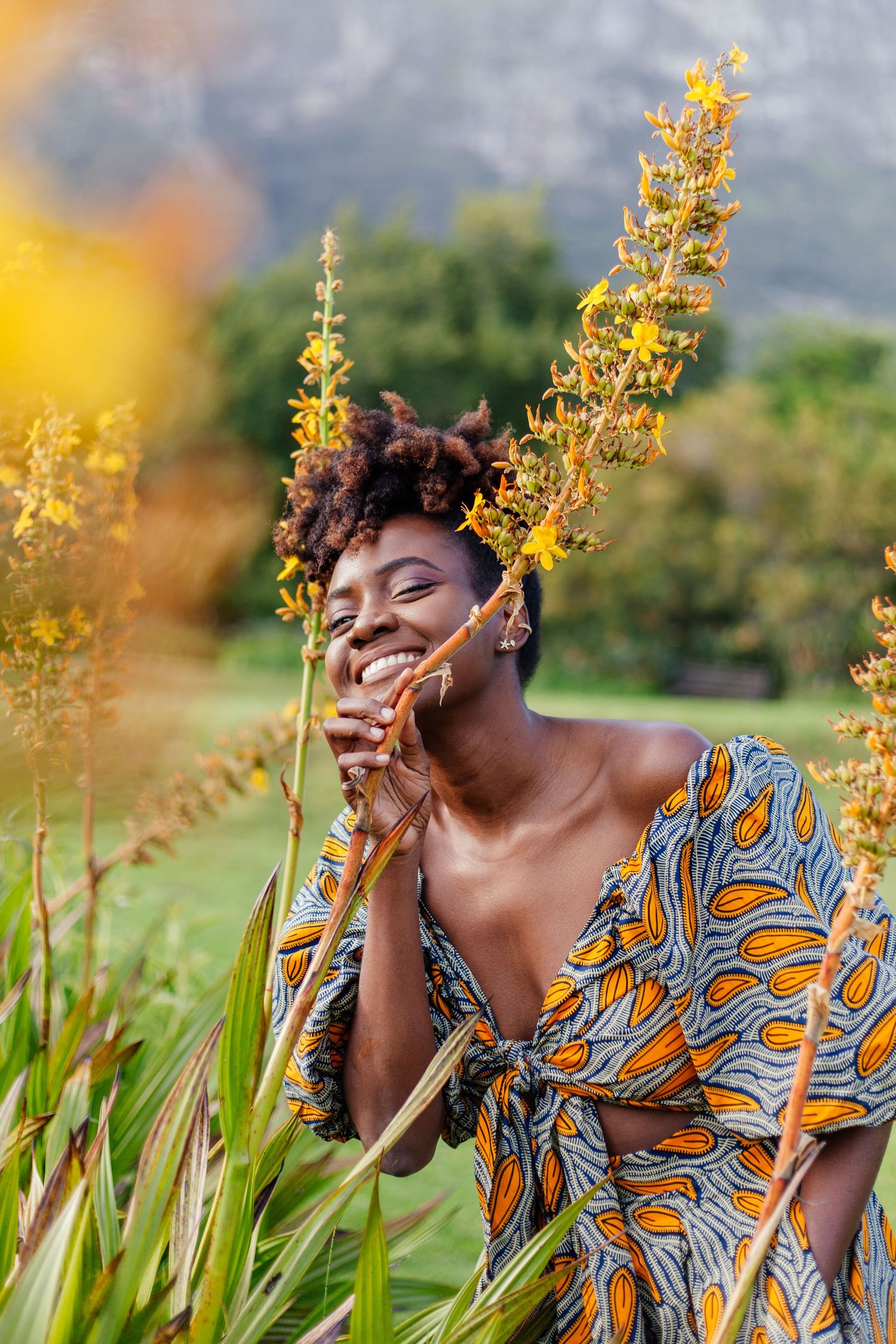 Joyful moment captured in yellow flowers wearing patterned dress outdoors.