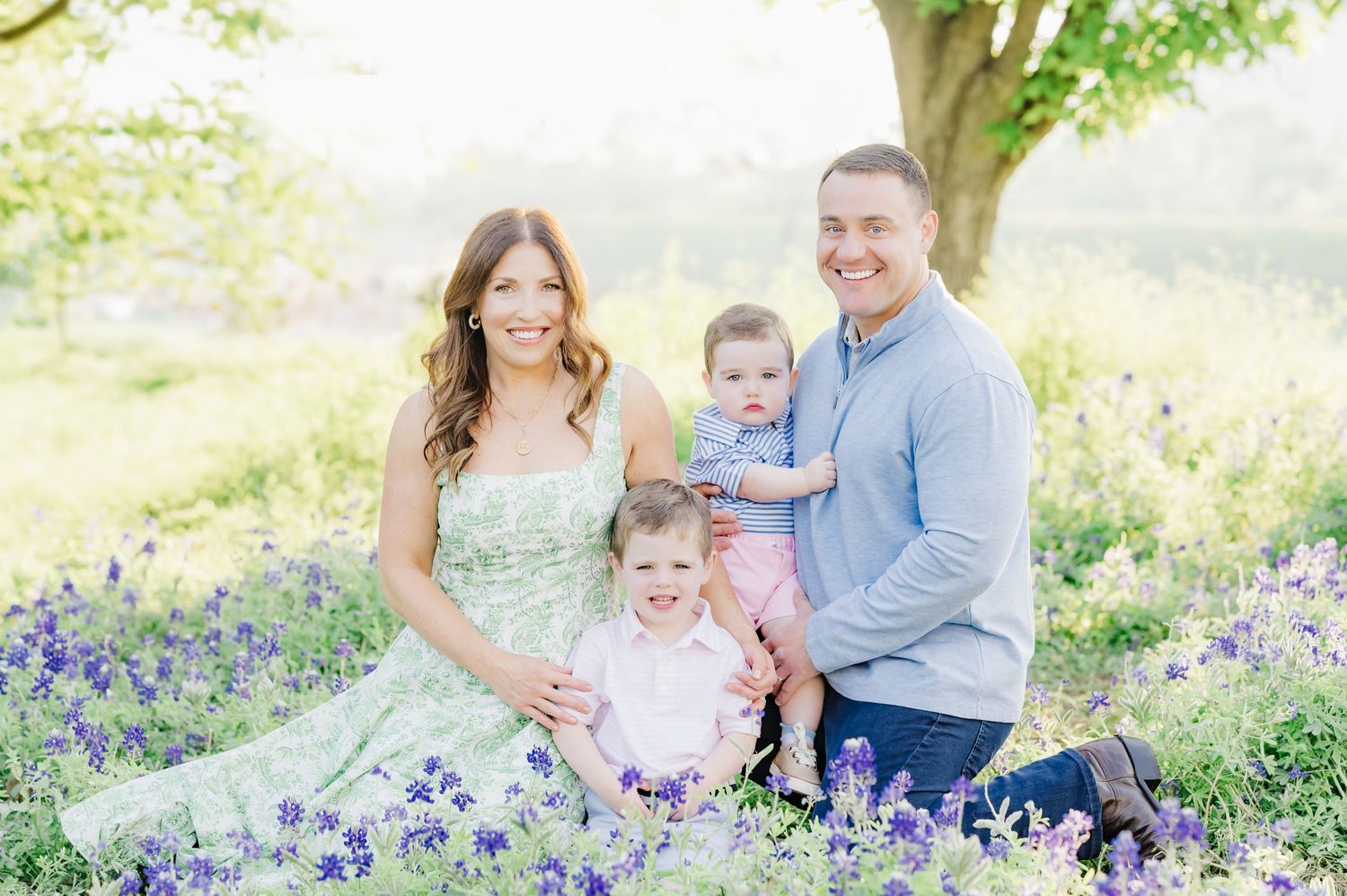Family photo session in field of bluebonnets showing playful interactions.