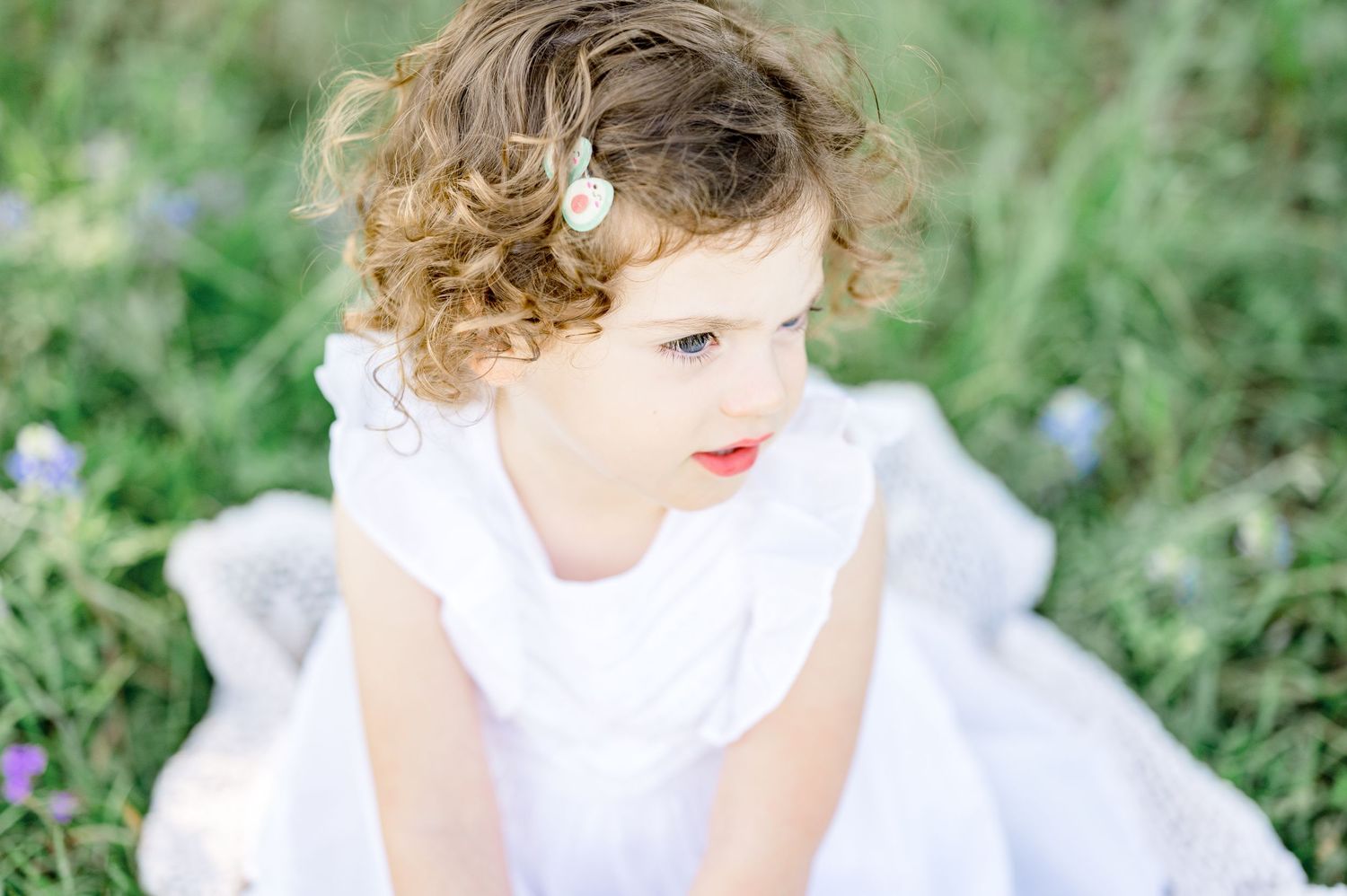Series of delicate portraits showing child in white dress among wildflowers.