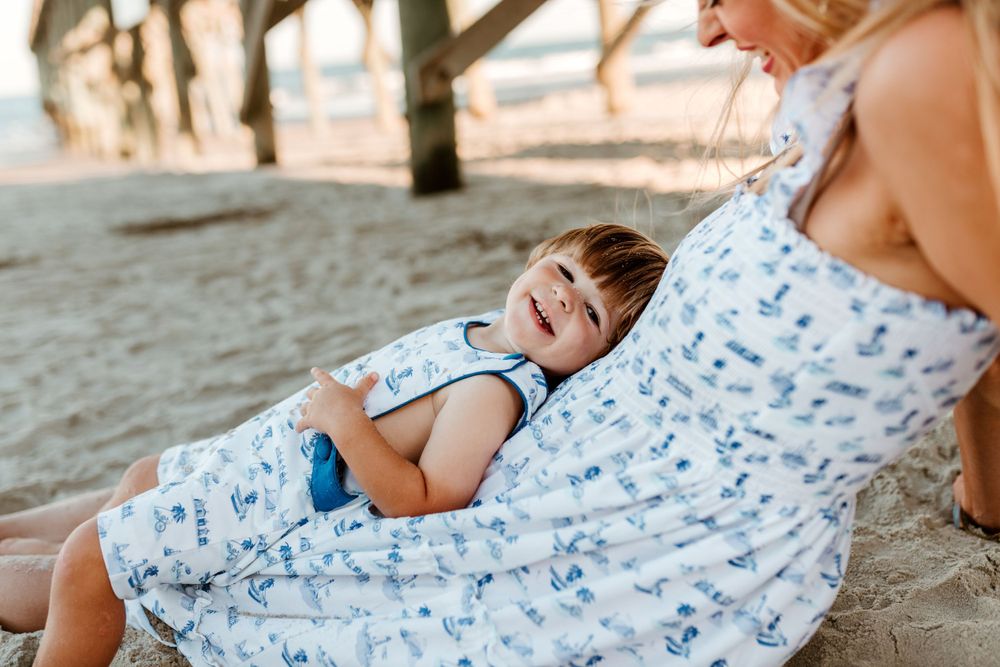 Candid moments of children playing together on sandy beach in matching outfits.