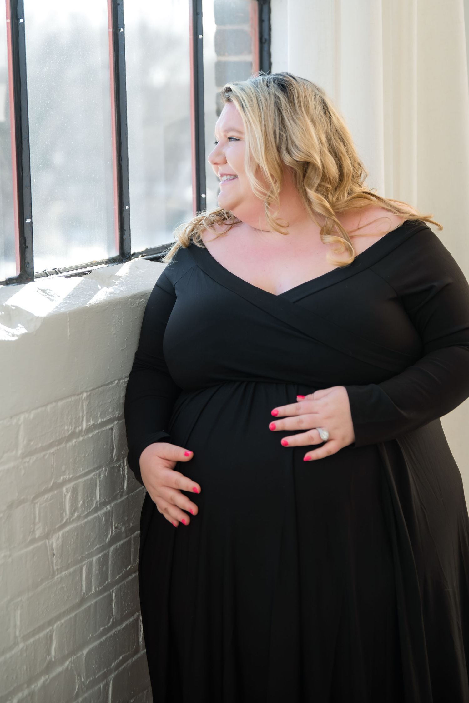 A series of three photos showing someone wearing a black dress against a white wall near windows.