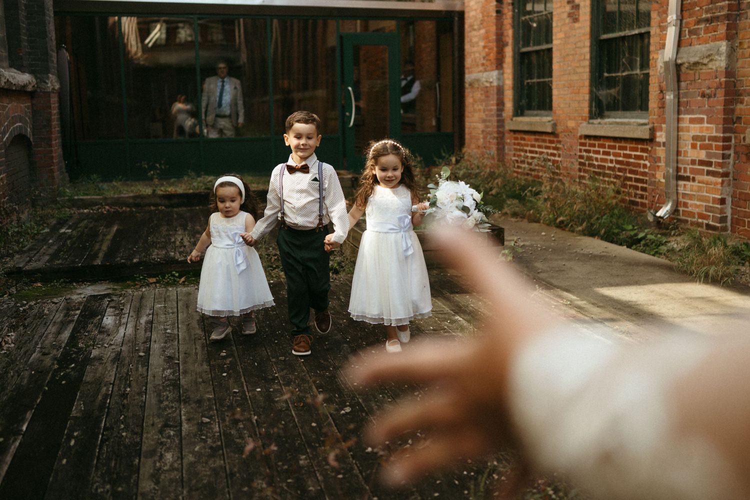 A couple shares an intimate moment during their wedding ceremony in a rustic brick chapel with stained glass windows.
