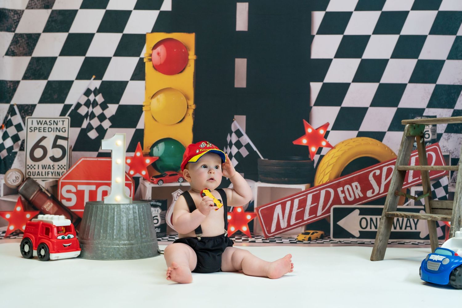 Colorful toy cars and racing decor arranged on a checkered pattern background with retro diner style elements.