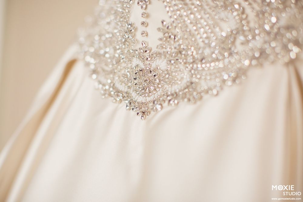 Close-up details of delicate beaded embellishments and lace on an ivory wedding dress.