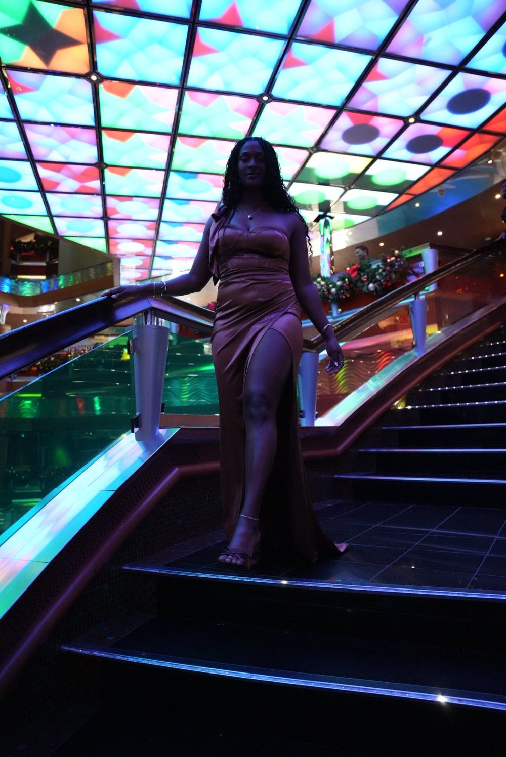 Colorful illuminated staircase with LED lights and geometric patterns creates a futuristic nightclub atmosphere.