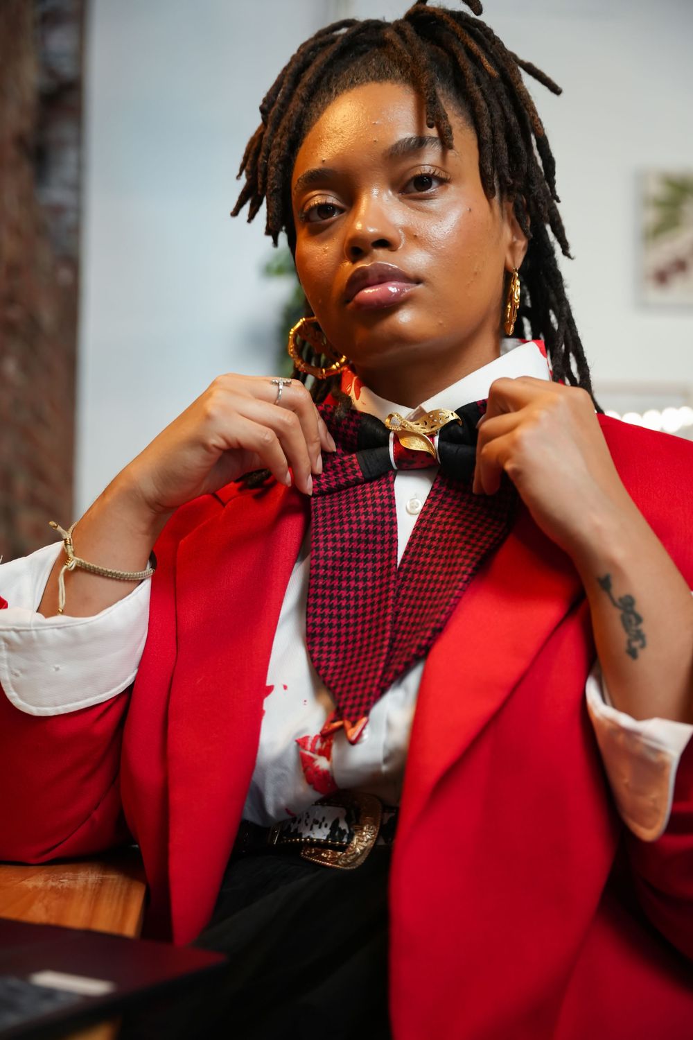 A series of close-up fashion portraits showing someone wearing a vibrant red blazer with a plaid vest and white shirt.