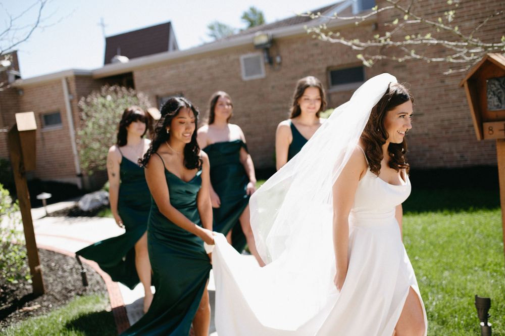 Wedding party walking outside with bride's dress flowing in the wind.