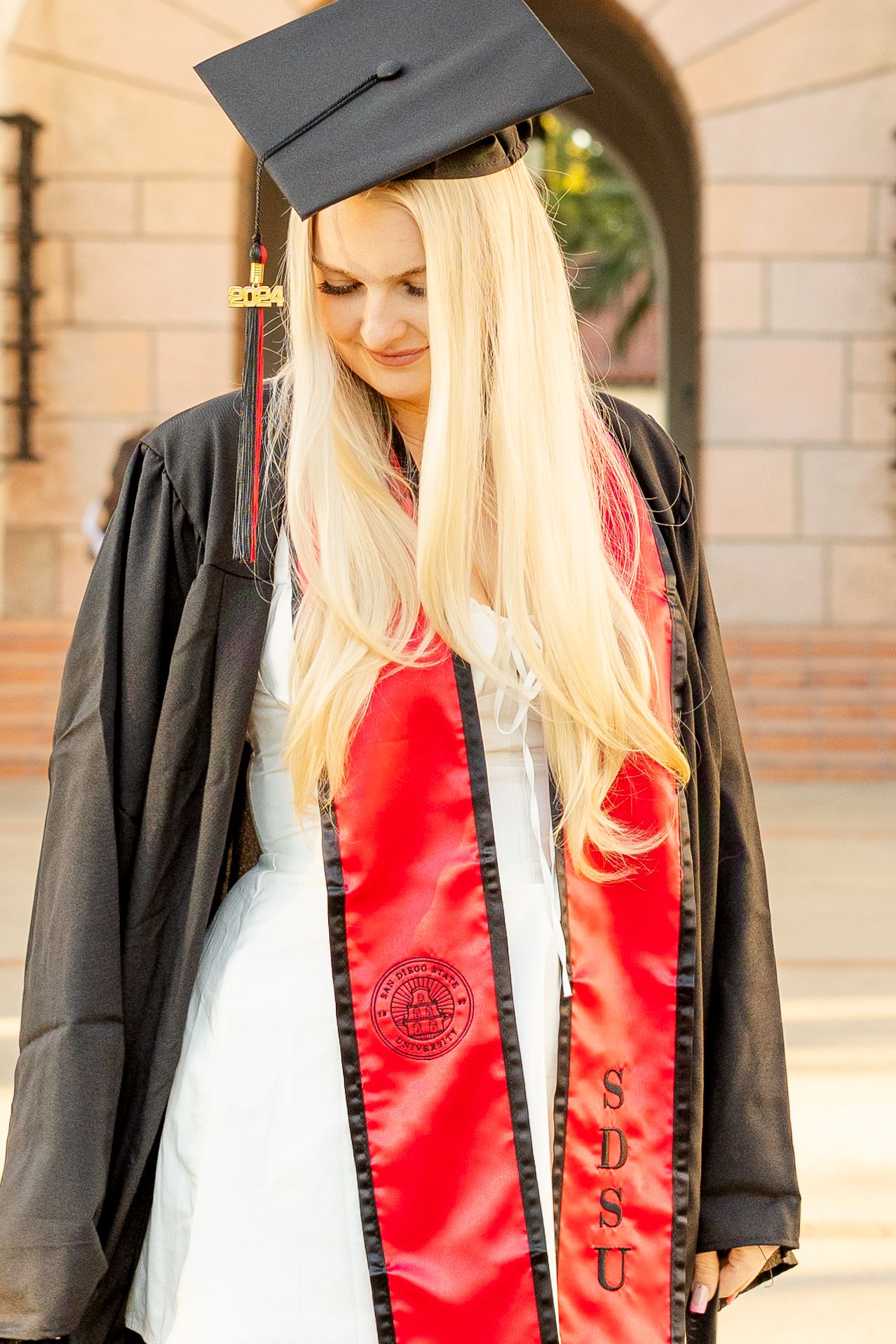 Senior portraits SDSU campus. Graduation portrait of SDSU senior in cap and gown on campus