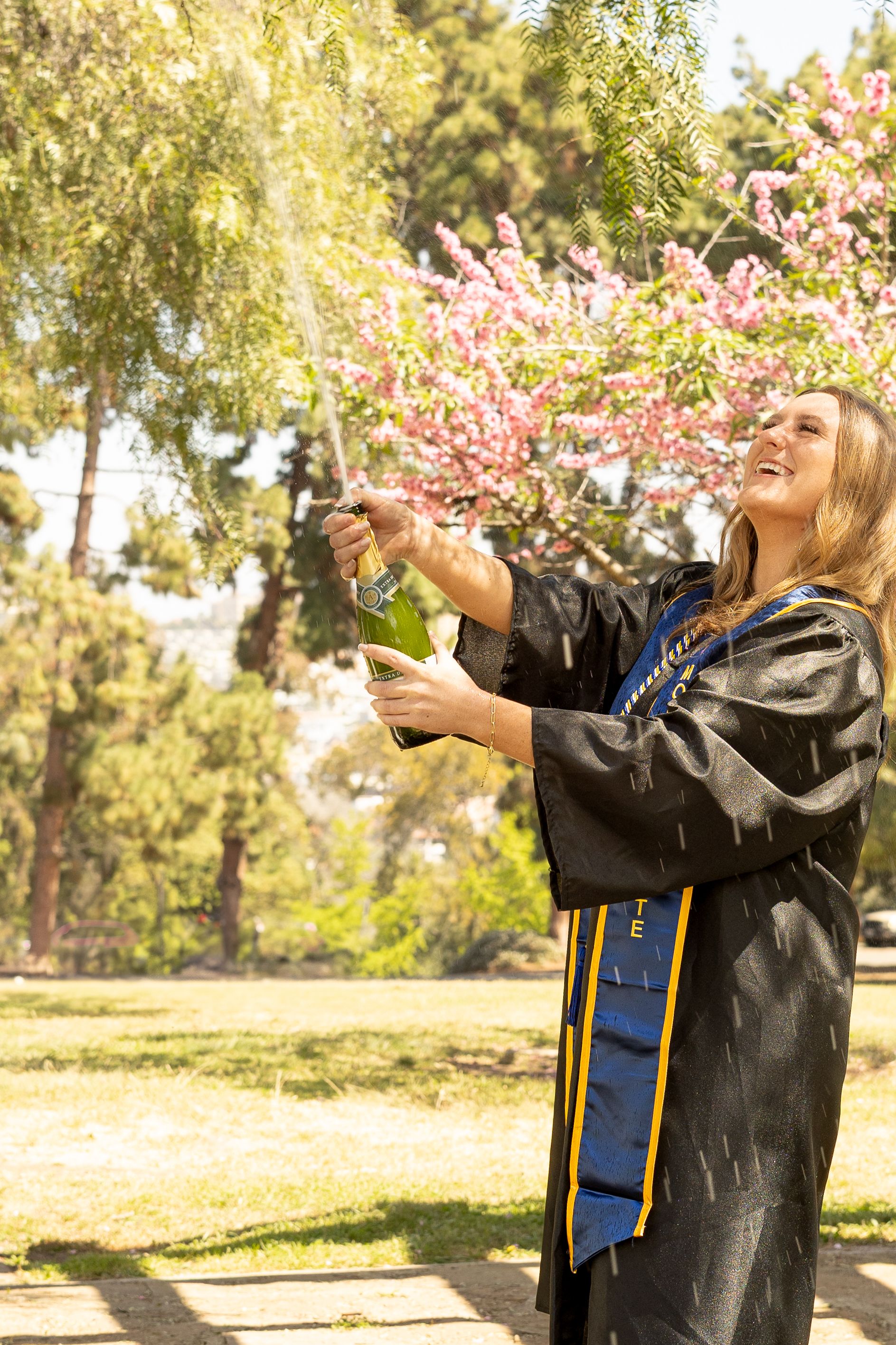 San Diego senior portrait with cap and gown under the trees at Presidio Park