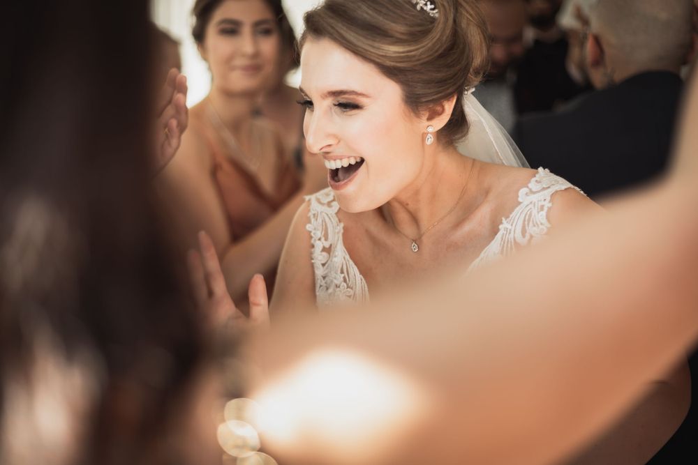 Brudpar dansar med glada gäster i bakgrunden på bröllopsfest