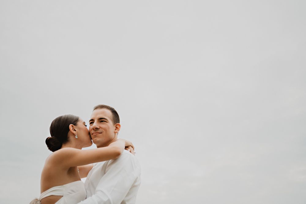 Bride kissing her partner on the cheek, capturing a sweet moment