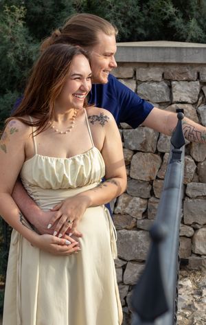 A romantic outdoor photoshoot showing a couple hugging near a stone wall. Engagement session Entrada of Westlake. Couples session.