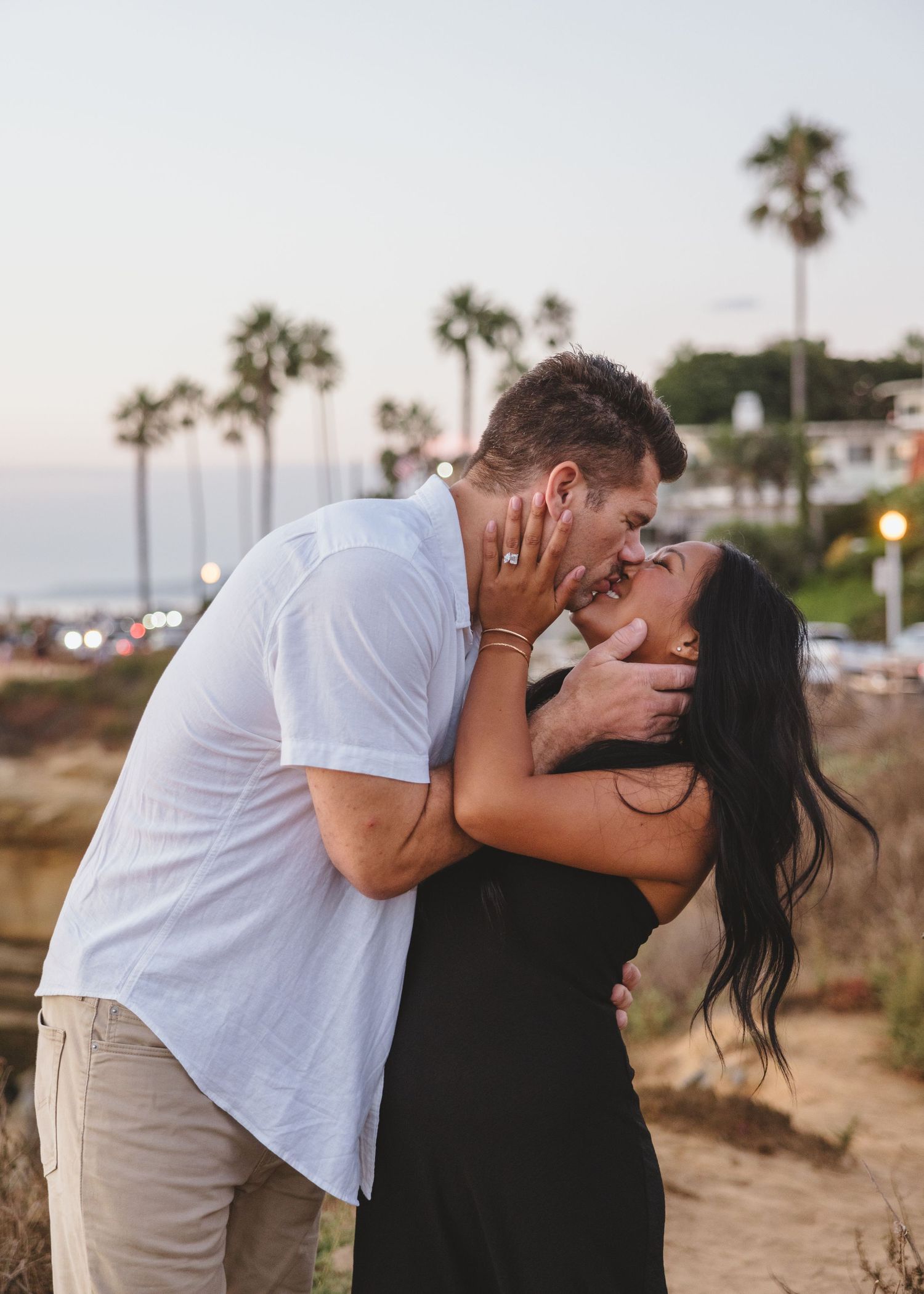 Intimate moment shared between couple on scenic coastal path at dusk.