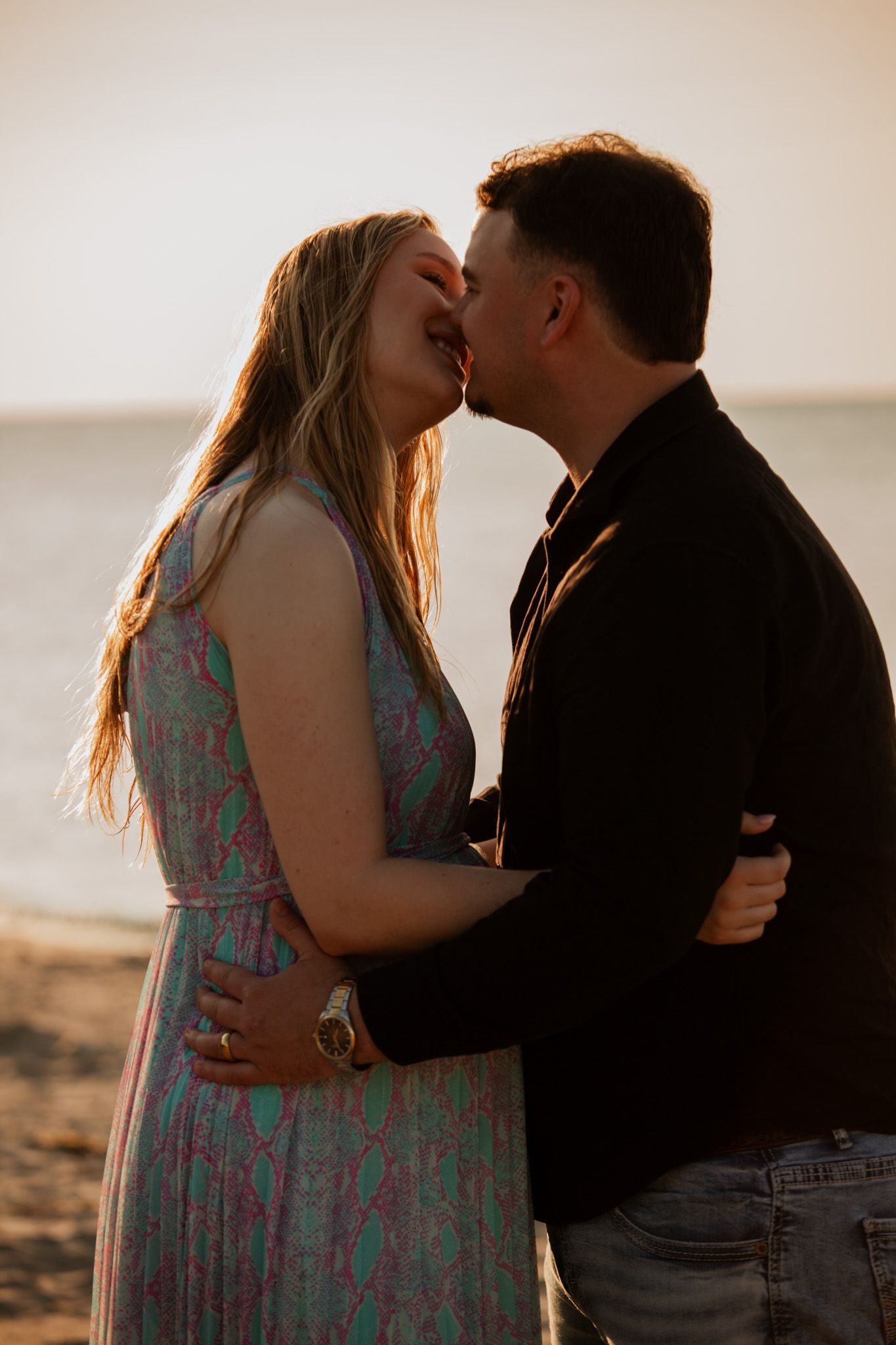 Romantic sunset photoshoot of couple on beach.