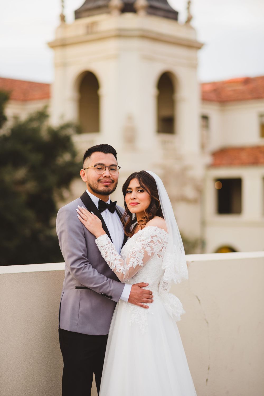 A newlywed couple poses for their wedding photos at Pasadena City Hall in Los Angeles County as they hold hands in love.